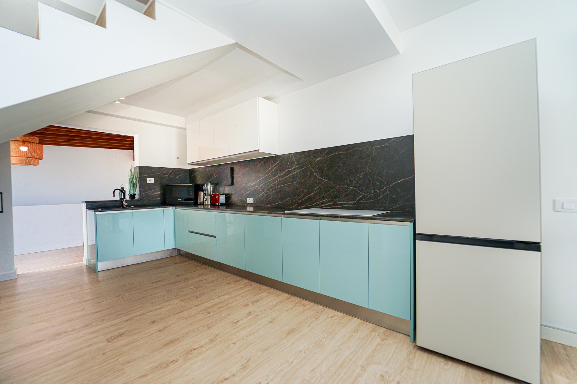 Modern kitchen with turquoise cabinets and marble backsplash
