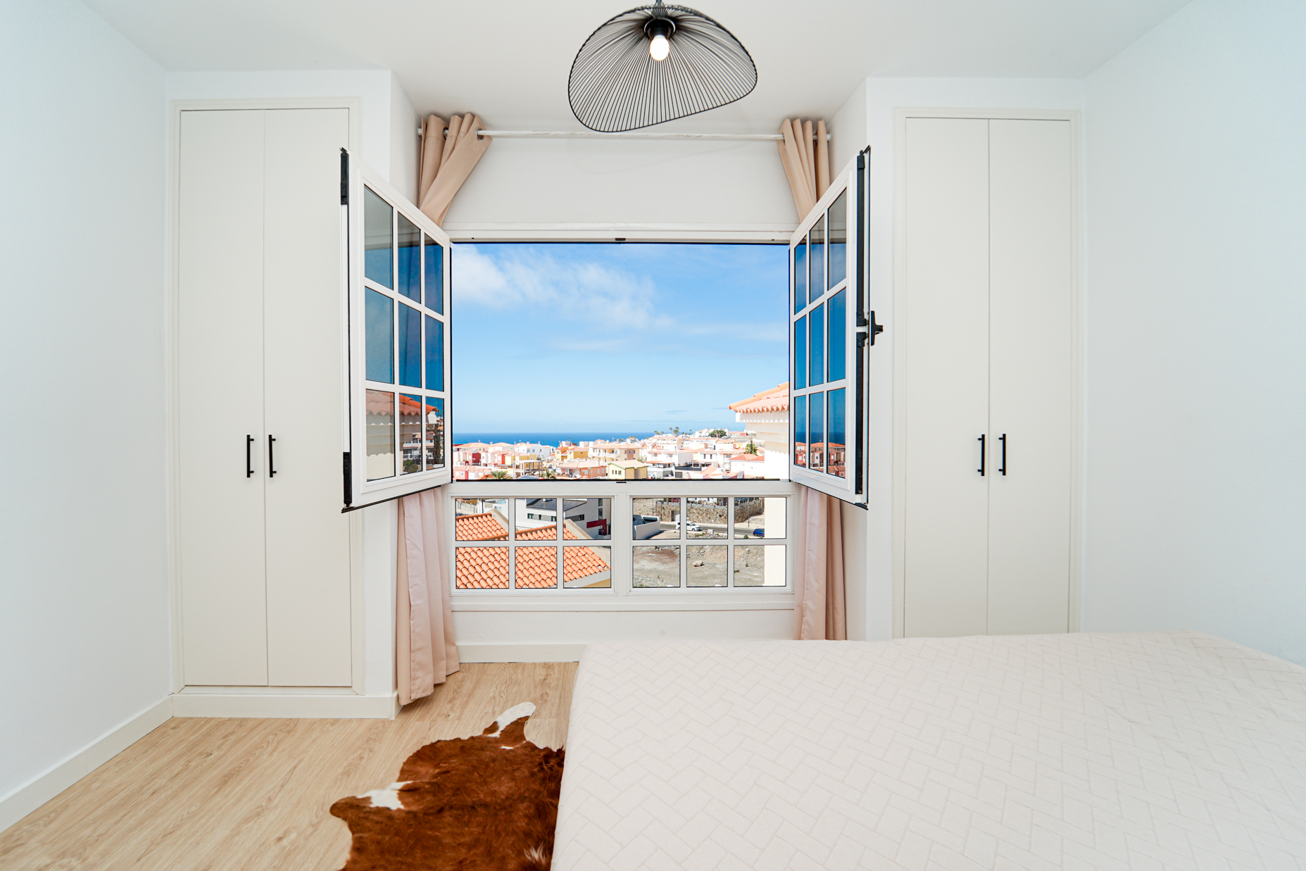 Arched windows showcasing panoramic coastal town and ocean views
